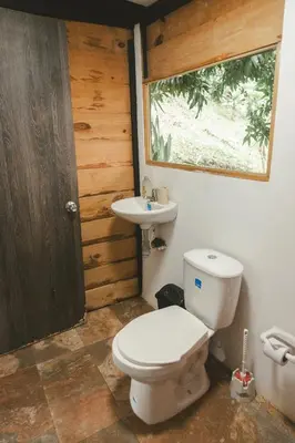 a bathroom with a toilet and a sink at Cabaña entre las montañas Tierra Mia - Eje Cafetero in Manizales
