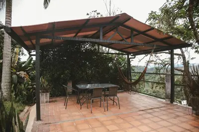 a wooden pergola with a table and chairs on a patio at Cabaña entre las montañas Tierra Mia - Eje Cafetero in Manizales