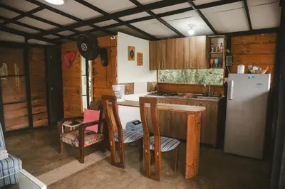 a kitchen with a refrigerator and a table and chairs at Cabaña entre las montañas Tierra Mia - Eje Cafetero in Manizales