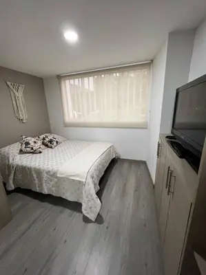 a bedroom with a bed and a flat screen tv at Urban 102 in Manizales