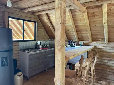 a kitchen with a table and chairs in a cabin at chalets A-MAR By la malcriada in Guarne