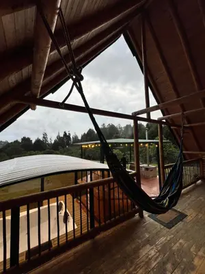 a hammock on a deck with a view of the water at chalets A-MAR By la malcriada in Guarne