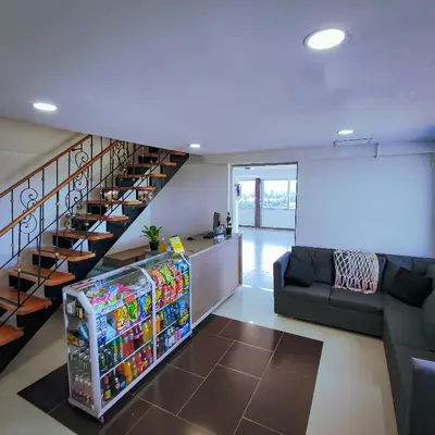 a living room with a soda machine next to a staircase at Hotel Ocaso Marinilla in Marinilla