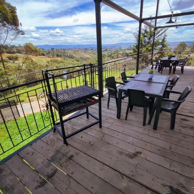 a wooden deck with a table and chairs on it at Hotel Ocaso Marinilla in Marinilla