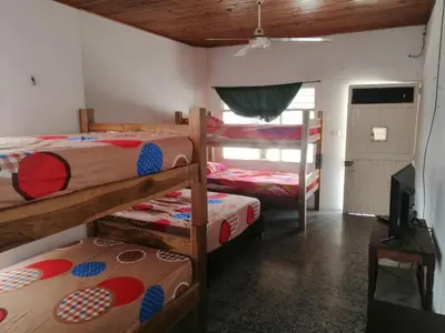 a room with three bunk beds and a television at Casa de relajación low cost in La Dorada