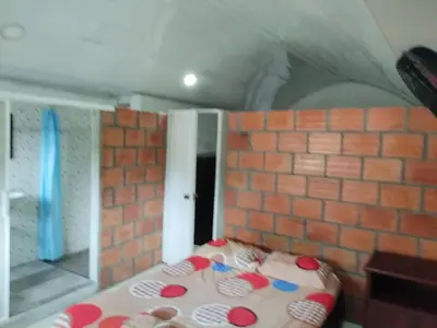 a room with a brick wall and a table at Casa de relajación low cost in La Dorada