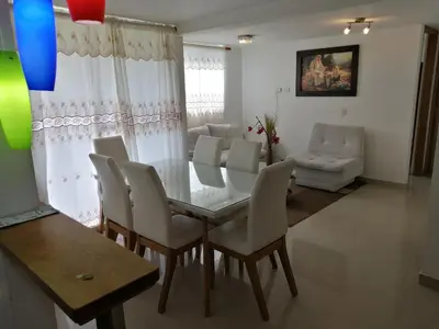 a dining room with a glass table and white chairs at Lindo Apartamento para estadía familiar in Rionegro