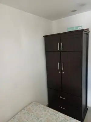 a bedroom with a wooden cabinet and a bed at Lindo Apartamento para estadía familiar in Rionegro