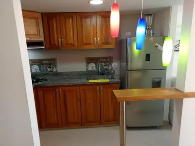 a kitchen with wooden cabinets and a stainless steel refrigerator at Lindo Apartamento para estadía familiar in Rionegro