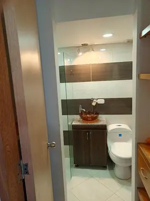 a bathroom with a toilet and a glass shower at Lindo Apartamento para estadía familiar in Rionegro