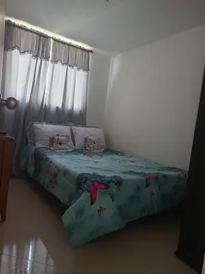 a bedroom with a bed with a green comforter at Lindo Apartamento para estadía familiar in Rionegro