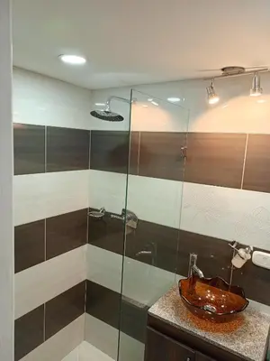 a bathroom with a sink and a glass shower at Lindo Apartamento para estadía familiar in Rionegro