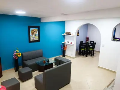 a living room with a couch and a blue wall at Hermosa casa en el mejor lugar! in Sabaneta
