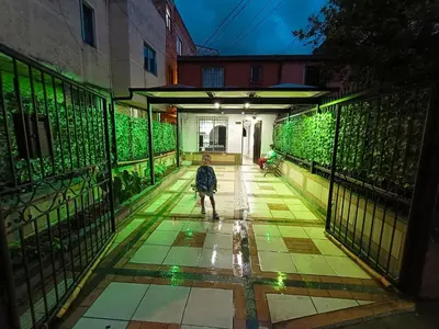 a child walking down a walkway with green lights at Hermosa casa en el mejor lugar! in Sabaneta