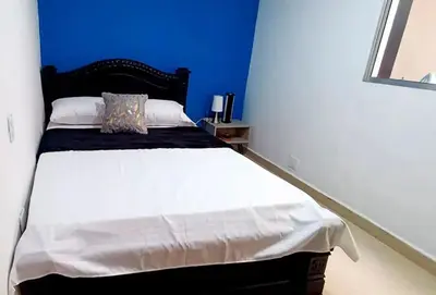 a bedroom with a large bed with a blue wall at Hermosa casa en el mejor lugar! in Sabaneta
