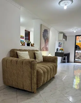 a living room with a brown couch in a room at Acogedor apartamento cerca al centro de Medellin in Medellín