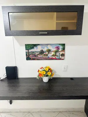 a wooden counter with a vase of flowers on it at Acogedor apartamento cerca al centro de Medellin in Medellín