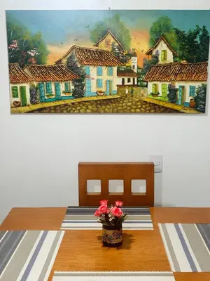 a dining room table with a painting on the wall at Acogedor apartamento cerca al centro de Medellin in Medellín