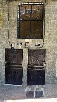 two sets of black doors on a brick building at Acogedor apartamento cerca al centro de Medellin in Medellín