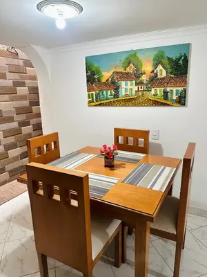 a dining room table with chairs and a painting on the wall at Acogedor apartamento cerca al centro de Medellin in Medellín