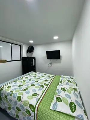 a bedroom with a bed with a green comforter at apartamento en Medellin, Santa Monica in Medellín