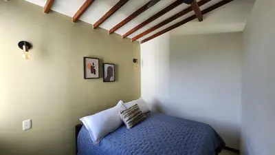 a bedroom with a blue bed in a room at Apartasol Club Ciudadela Santa Fe - Santa Fe de Antioquia in Santa Fe de Antioquia