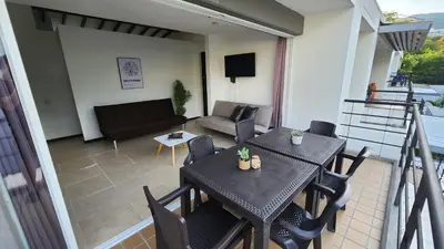 a balcony with a table and chairs and a couch at Apartasol Club Ciudadela Santa Fe - Santa Fe de Antioquia in Santa Fe de Antioquia