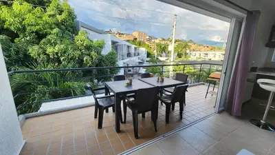 a patio with a table and chairs on a balcony at Apartasol Club Ciudadela Santa Fe - Santa Fe de Antioquia in Santa Fe de Antioquia