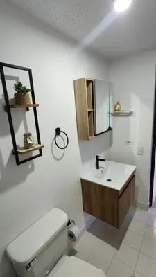 a bathroom with a toilet and a sink and a mirror at Apartasol Club Ciudadela Santa Fe - Santa Fe de Antioquia in Santa Fe de Antioquia