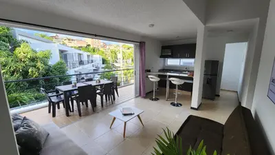 a living room with a dining table and a kitchen at Apartasol Club Ciudadela Santa Fe - Santa Fe de Antioquia in Santa Fe de Antioquia