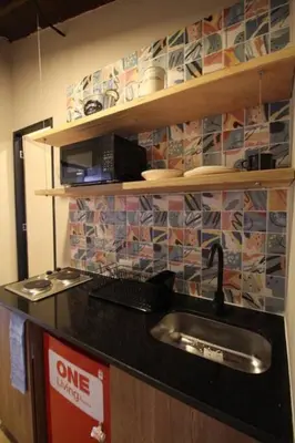 a kitchen counter with a sink and a microwave at Apartamento con parqueadero en Medellín -ONE201 By Roots Rentals in Medellín