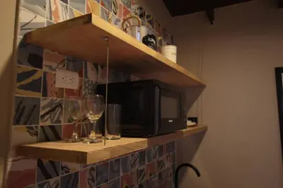 a shelf with a television and wine glasses on it at Apartamento con parqueadero en Medellín -ONE201 By Roots Rentals in Medellín