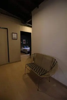 a chair in a room with a room with a bed at Apartamento con parqueadero en Medellín -ONE201 By Roots Rentals in Medellín