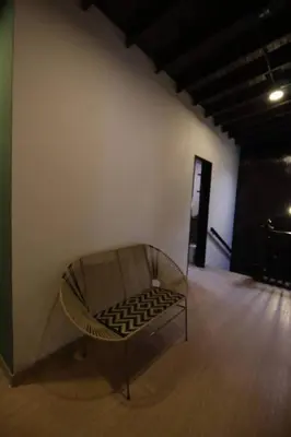 a chair sitting in a room with a wall at Apartamento con parqueadero en Medellín -ONE201 By Roots Rentals in Medellín