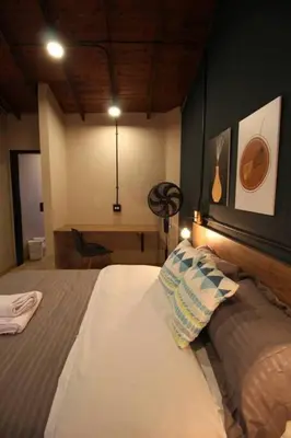 a bedroom with a large bed and a desk at Apartamento con parqueadero en Medellín -ONE201 By Roots Rentals in Medellín