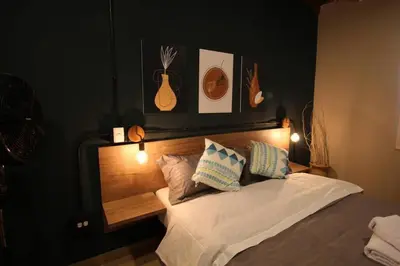 a bedroom with a bed with a wooden head board at Apartamento con parqueadero en Medellín -ONE201 By Roots Rentals in Medellín