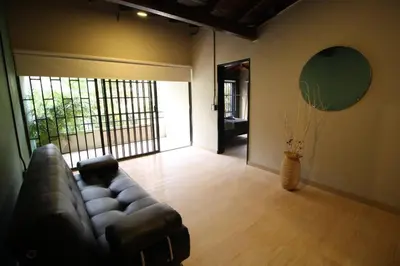 a living room with a leather couch and a window at Apartamento cerca Unidad Deportiva Belén - ONE202 By Roots Rentals in Medellín