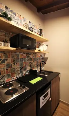 a kitchen with a stove and a microwave at Apartamento cerca Unidad Deportiva Belén - ONE202 By Roots Rentals in Medellín