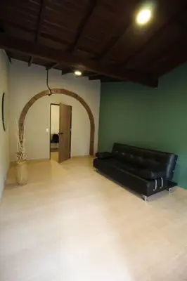 a black leather couch in a room with an arch at Apartamento cerca Unidad Deportiva Belén - ONE202 By Roots Rentals in Medellín