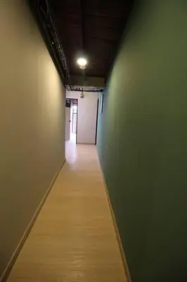 a hallway with green walls and a wooden floor at Apartamento cerca Unidad Deportiva Belén - ONE202 By Roots Rentals in Medellín