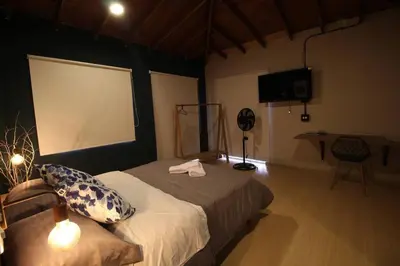 a bedroom with a bed and a large screen at Apartamento cerca Unidad Deportiva Belén - ONE202 By Roots Rentals in Medellín