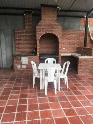 a patio with a table and chairs and a brick oven at QUINTA CAMPESTRE LA FLORIDA in Mariquita