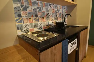 a small kitchen with a stove and a sink at Apartamento Centro Comercial los Molinos - ONE203 By Roots Rentals in Medellín