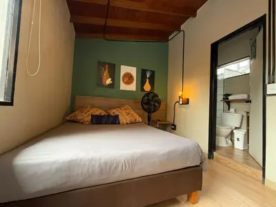 a bedroom with a large bed and a bathroom at Apartamento cerca a clínica las Américas - ONE204 By Roots Rentals in Medellín