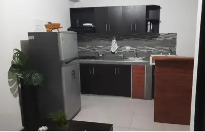 a kitchen with black cabinets and a white refrigerator at Alejandría 1 in Itagüí
