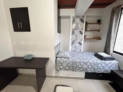 a small bedroom with a bed and a desk at Alejandría 1 in Itagüí