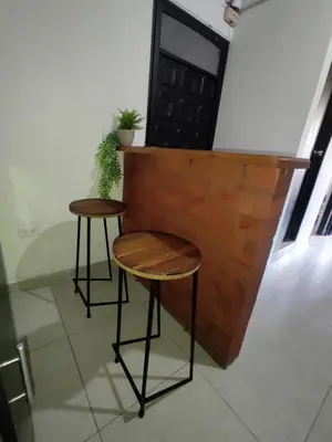 two tables and stools in front of a brick wall at Alejandría 1 in Itagüí