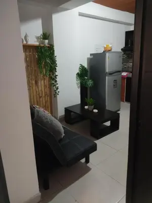 a living room with a black couch and a refrigerator at Alejandría 1 in Itagüí