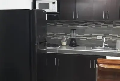 a kitchen with a stove and a sink and a refrigerator at Alejandría 1 in Itagüí