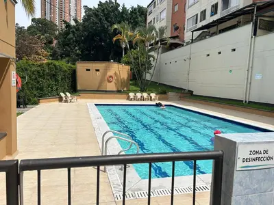 a swimming pool with chairs next to a building at Modern, Apt/near tourist sites. in Medellín